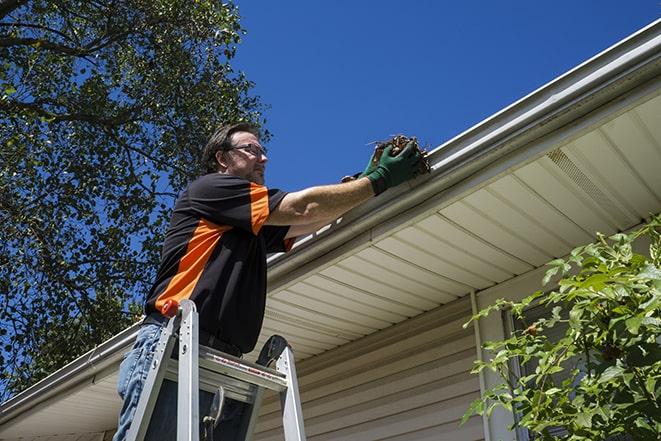 fixing a leaky gutter with new screws and brackets in Chestnut Hill
